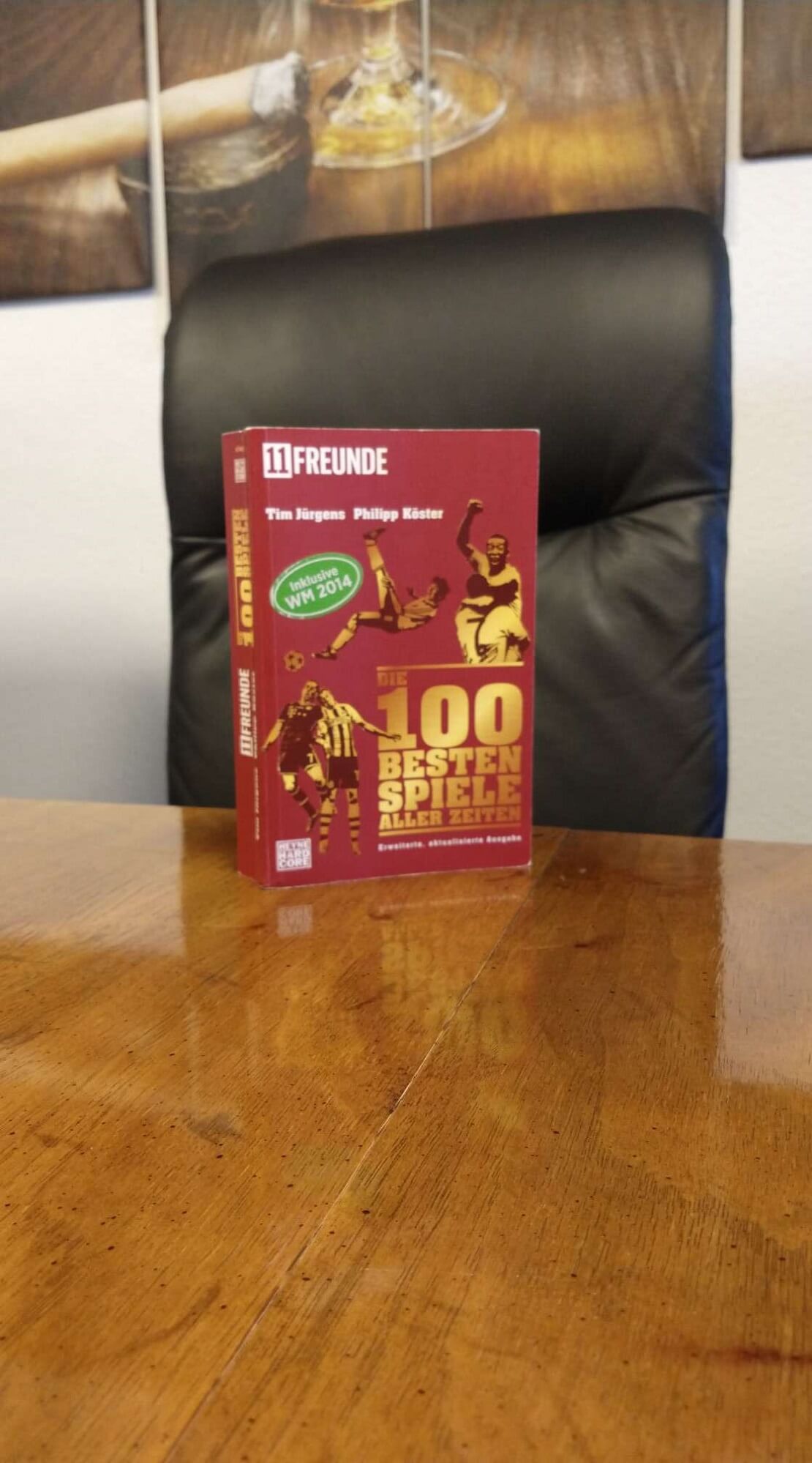 Das Buch "Die 100 besten Spiele aller Zeiten" auf einem Holztisch
