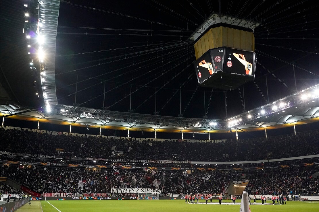 Voll besetztes Stadion mit Videowürfel und Flutlicht