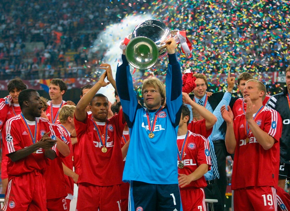 Oliver Kahn reckt die Champions League Trophäe hoch, Bayern SPielern um ihn herum