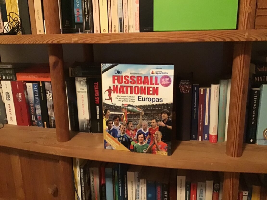 Frontansicht des Buches "Die Fußball Nationen Europas" im Regal mit anderen Büchern.