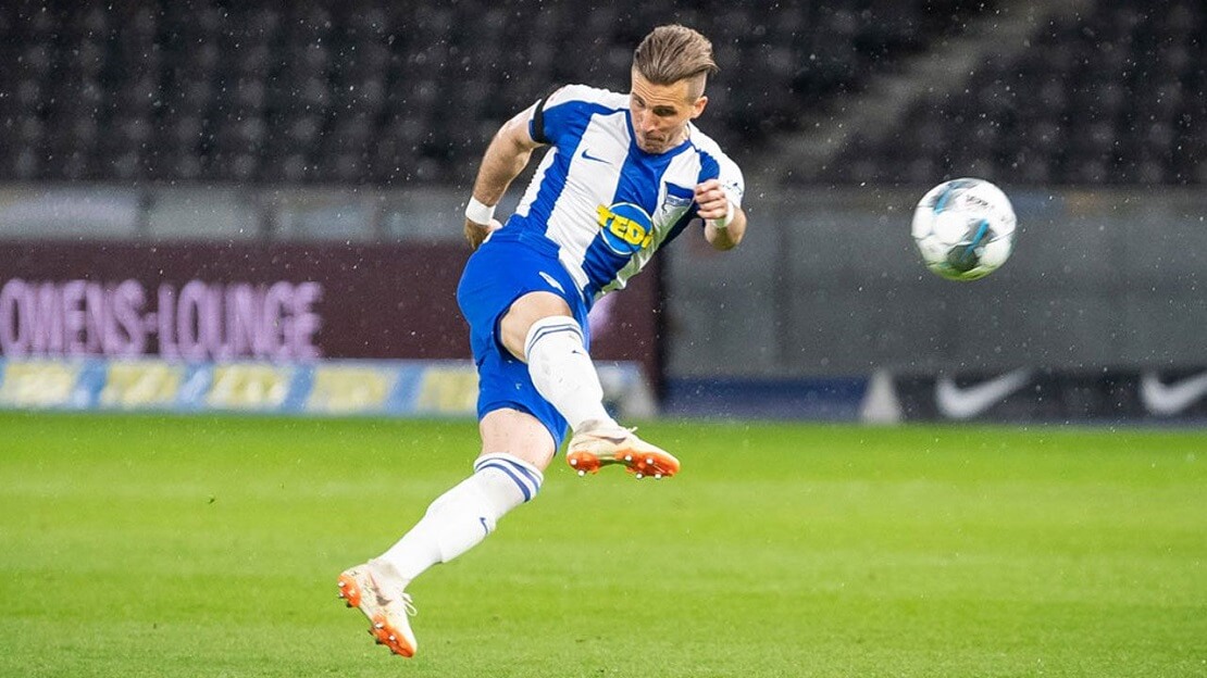 Fußballer Peter Pekartik steht auf dem Fußballfeld und spielt einen Ball