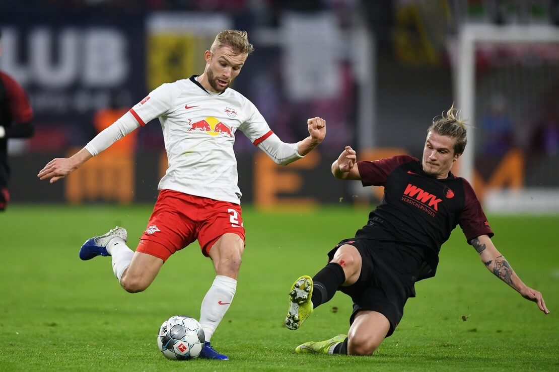 Spieler von RB Leipzig spielt den Ball neben ihm ein Spieler von FC Augsburg