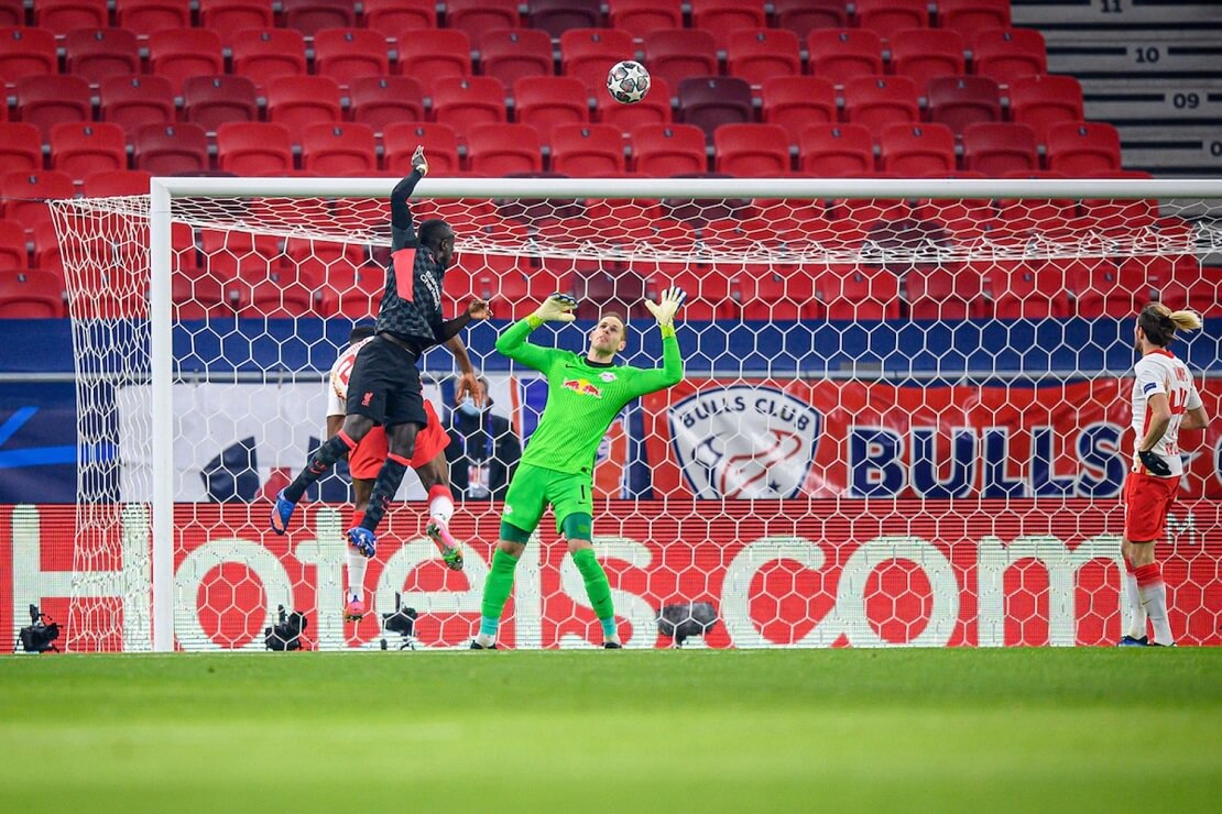 Sadio Mane von Liverpool FC springt höher als ein Leipziger Verteidiger, Leipzigs Torwart versucht den Kopfball abzuwehren