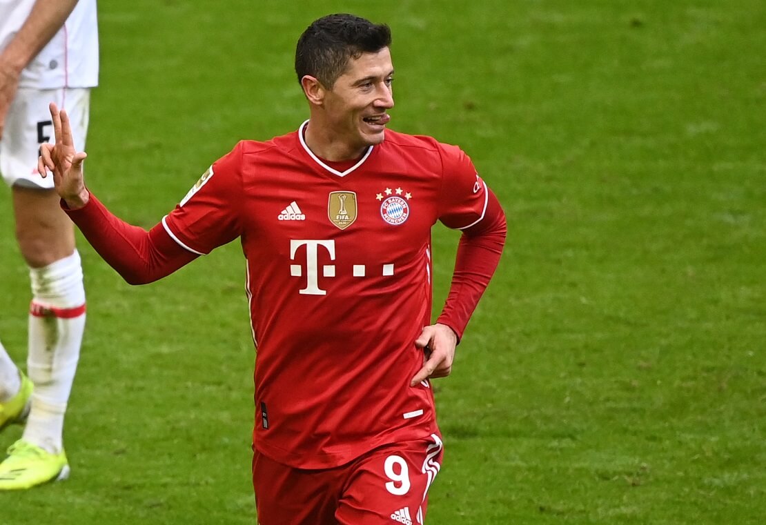 Robert Lewandowski jubelt mit ausgestreckter Zunge und drei gespreizten Fingern