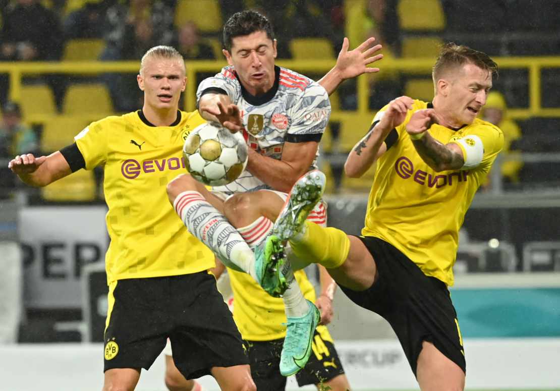 Robert Lewandowski führt einen Zweikampf mit Marco Reus, Erling Haaland schaut zu