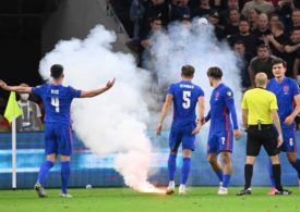 Spieler der englischen Nationalmannschaft diskutieren mit ungarischen Fans, auf dem Boden liegt ein Bengalo