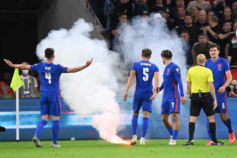 Spieler der englischen Nationalmannschaft diskutieren mit ungarischen Fans, auf dem Boden liegt ein Bengalo