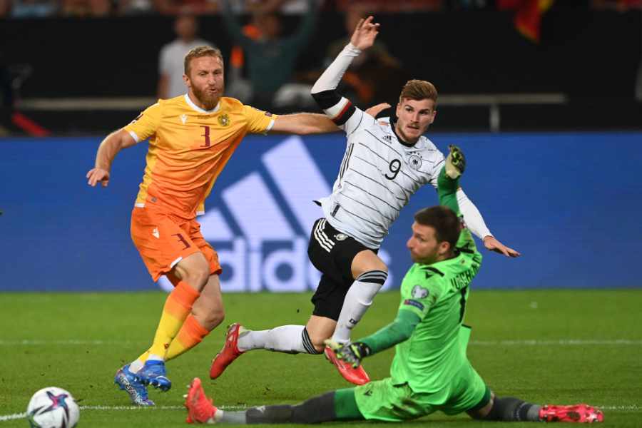 Timo Werner spielt den Ball im Fallen an Torwart und Verteidiger von Armenien vorbei