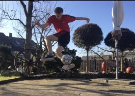 Ein junger Mann macht im Garten Tricks mit einem Fußball