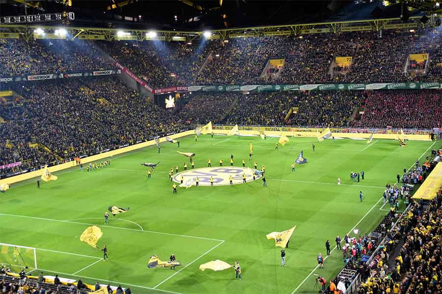 Stadion von Borussia Dortmund, auf dem Spielfeld wird mit BVB Fahnen gewedelt