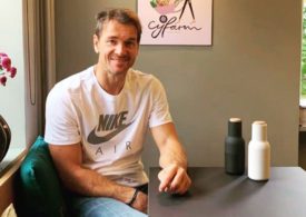 Jens Lehmann sitzt mit Alltagskleidung an einem Tisch