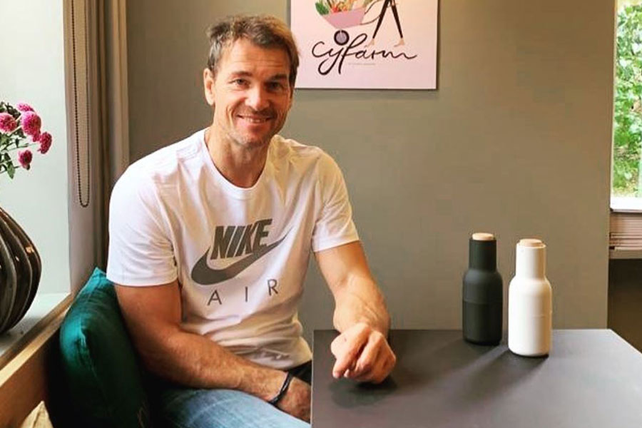 Jens Lehmann sitzt mit Alltagskleidung an einem Tisch