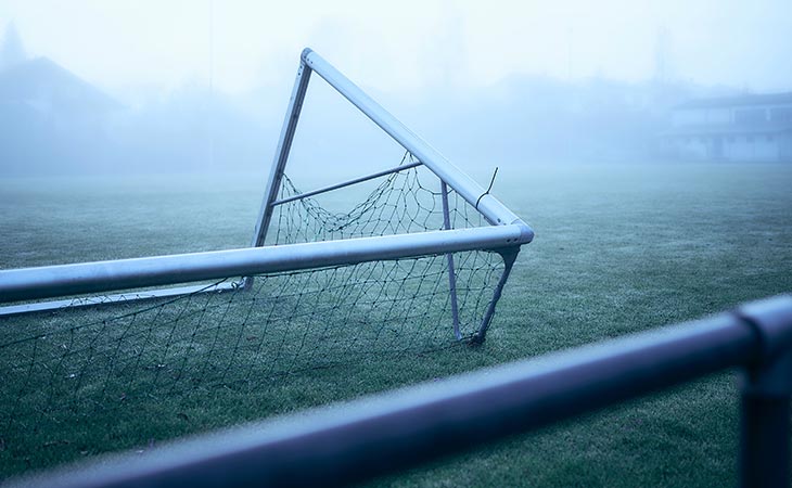 Kaputtes Tor auf dem Fußballfeld im Nebel