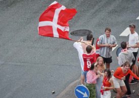 Dänemarkfans jubeln mit einer Flagge auf der Straße