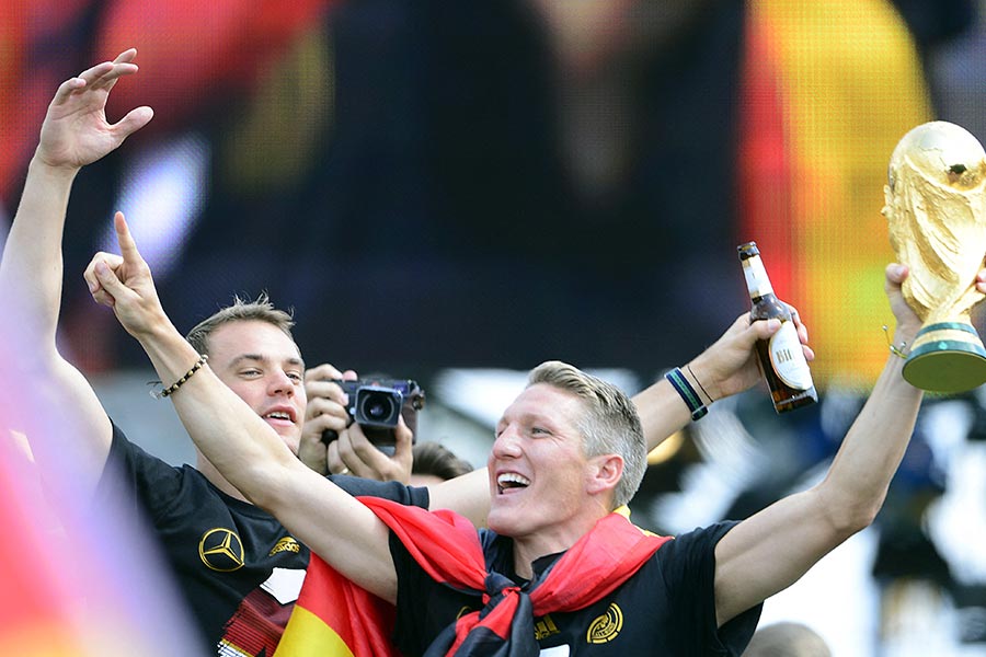 Manuel Neuer und Bastian Schweinsteiger halten den WM Pokal und jubeln.