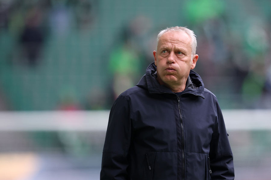 Der Trainer Christian Streich bläst seine Wangen auf