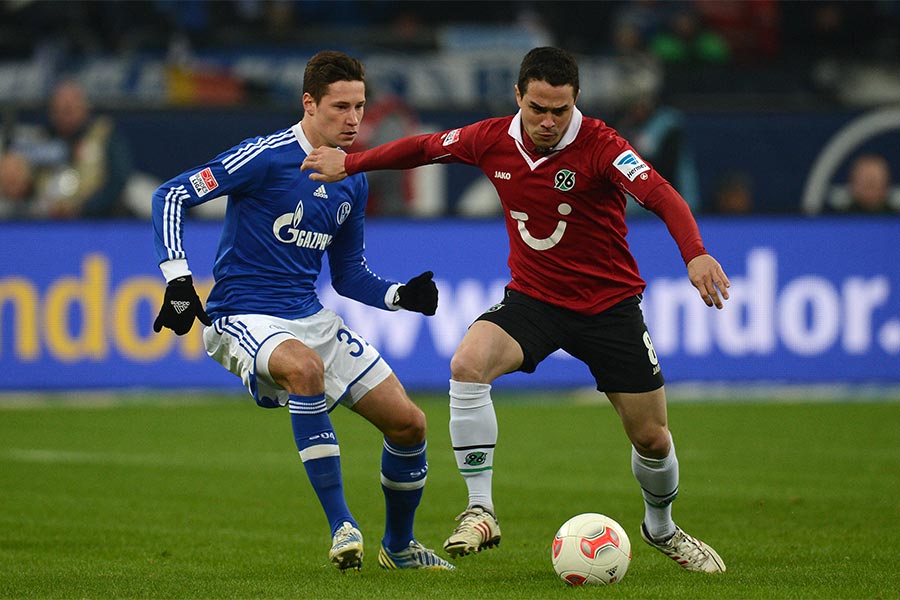 Zwei Fußballspieler spielen gegen einander um einen Fußball